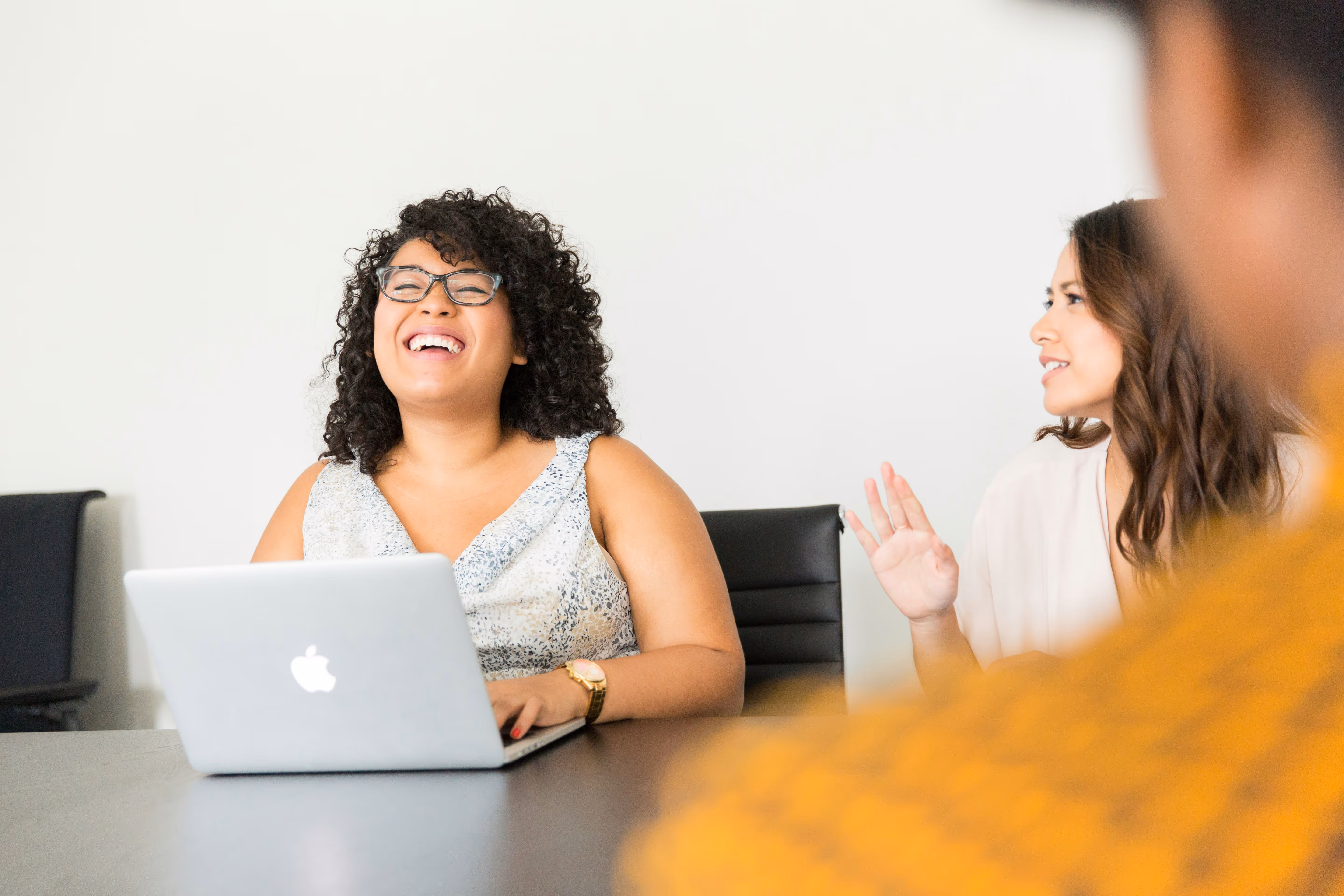 Woman smiling at laptop, with text overlays reading “Build momentum”, “Tackle challenges” and “Client-first”